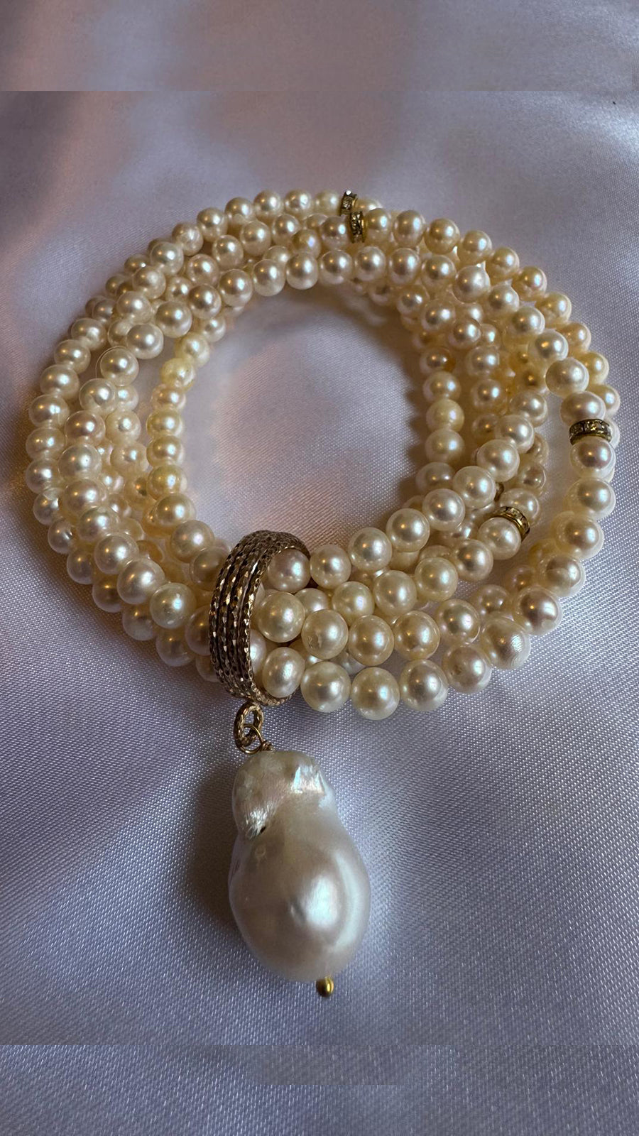 Multi strand, stretchy pearl bracelet  with pendant.