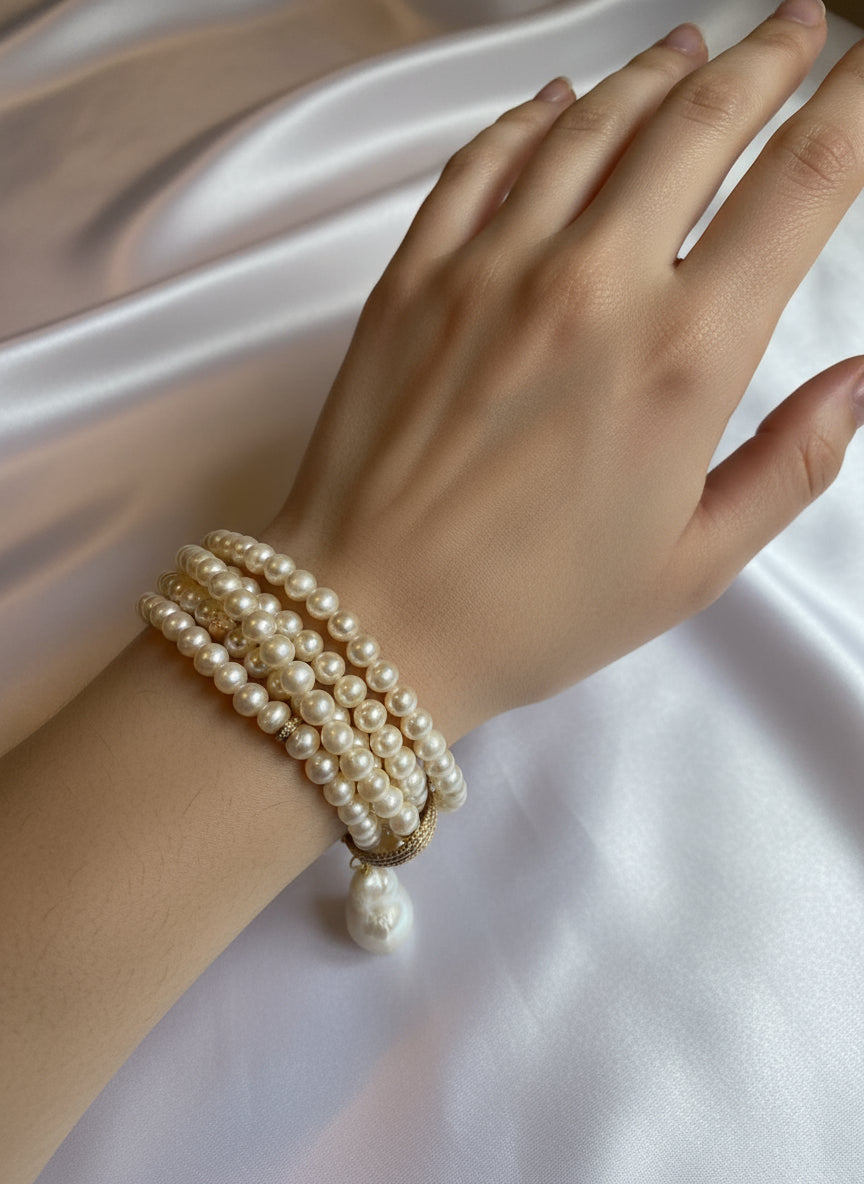 Pearl bracelet with a large pearl pendant.