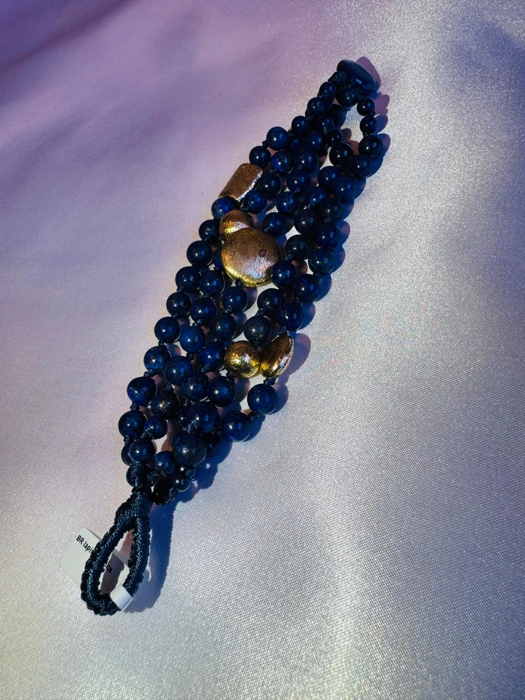 Multi strand lapis lazuli and nugget bracelet with a golden centerpiece