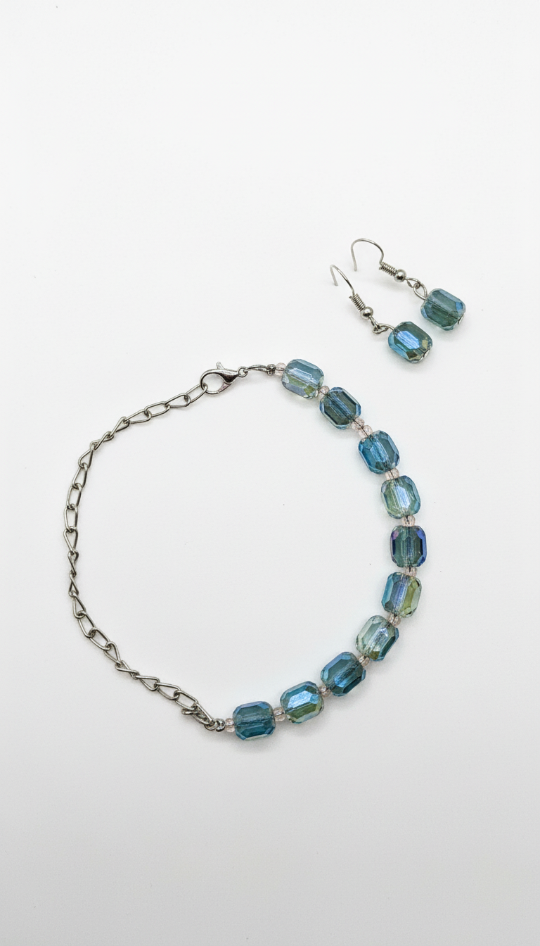 Bracelet et boucles d'oreilles en cristal de verre gris fumé et bleu, ornés de perles, avec une chaîne métallique argentée.