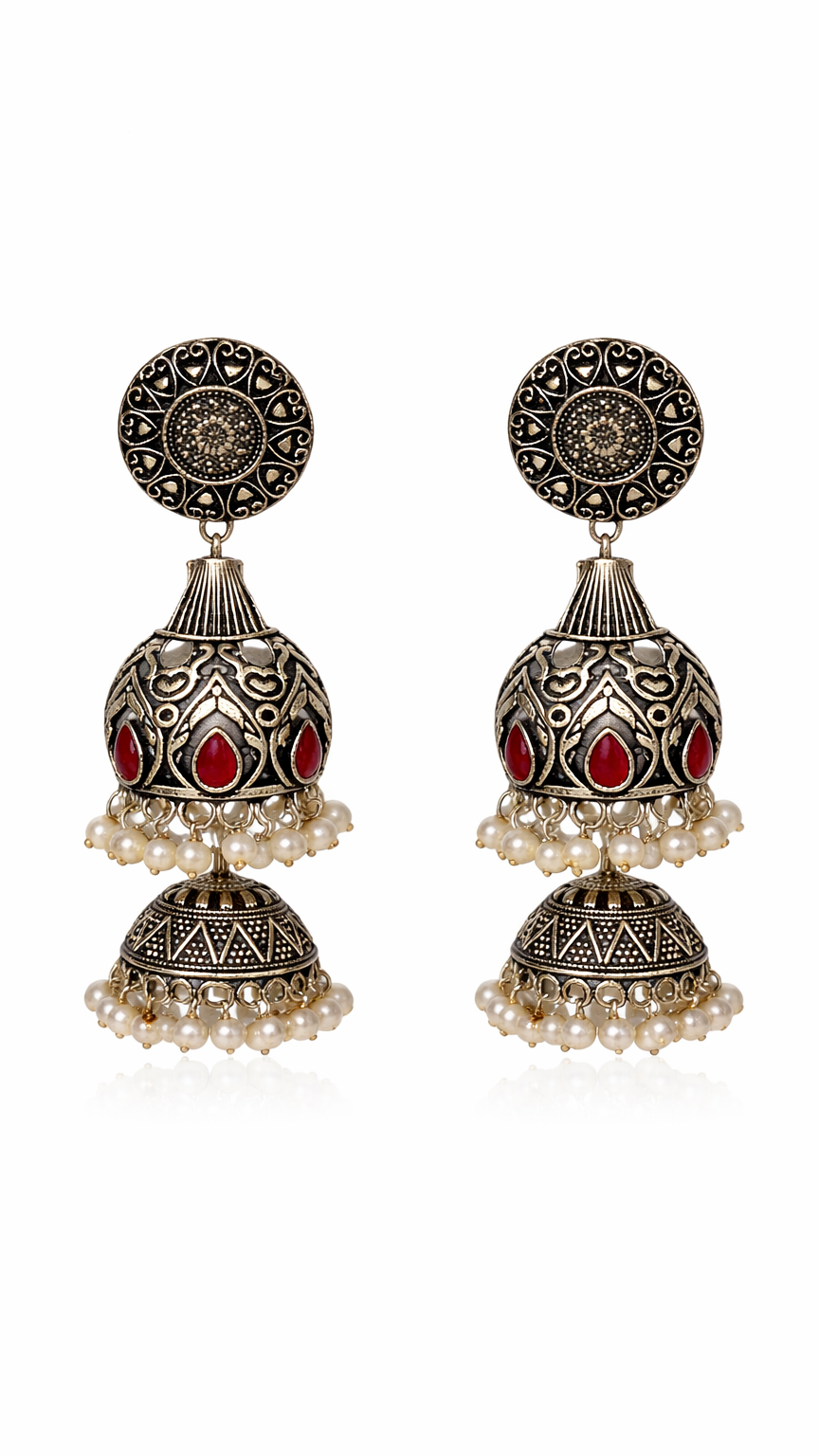 Boucles d'oreilles argentées en métal gravé, ornées de pierres rouges et d'une bordure en perle blanche.