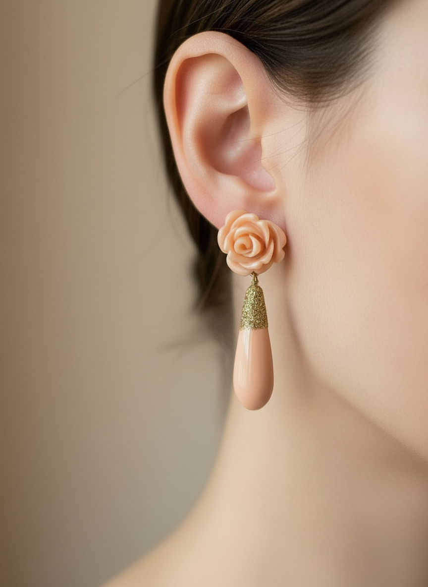 Close-up of an ear wearing a unique earring with a rose and teardrop design.
