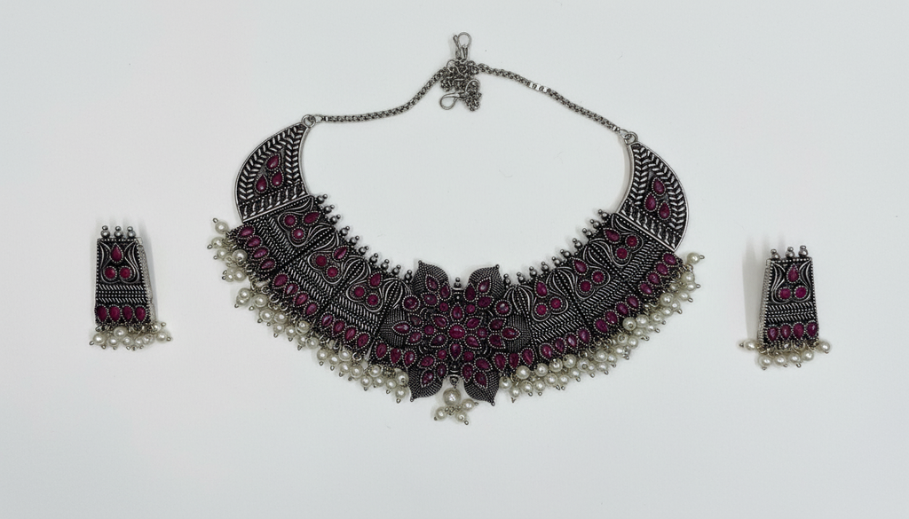 Collier en métal oxydé, orné de pierres marron et de perles blanches, au design à la fois audacieux et traditionnel.
