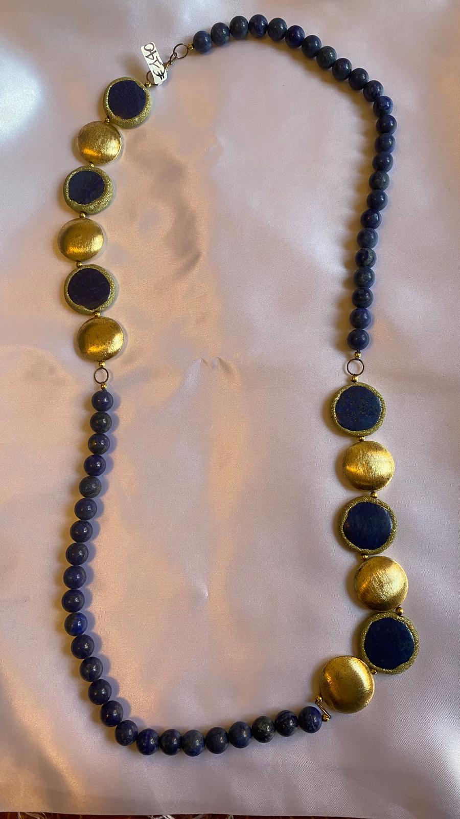 Collana in lapislazzuli e pepite con perline blu e dettagli circolari dorati.
