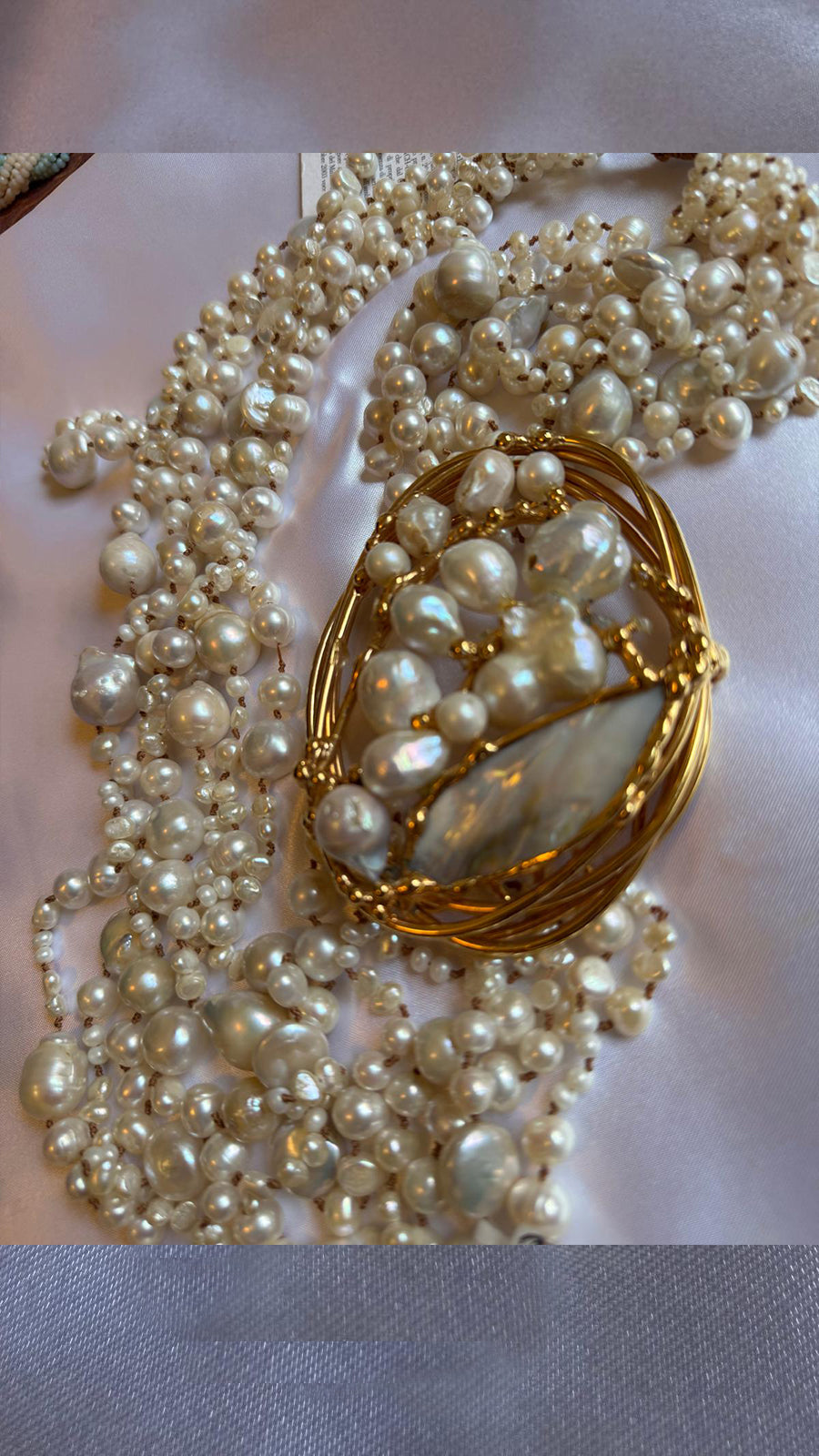 Multi-strand necklace with freshwater pearls and mother-of-pearl, in gold-plated metal.