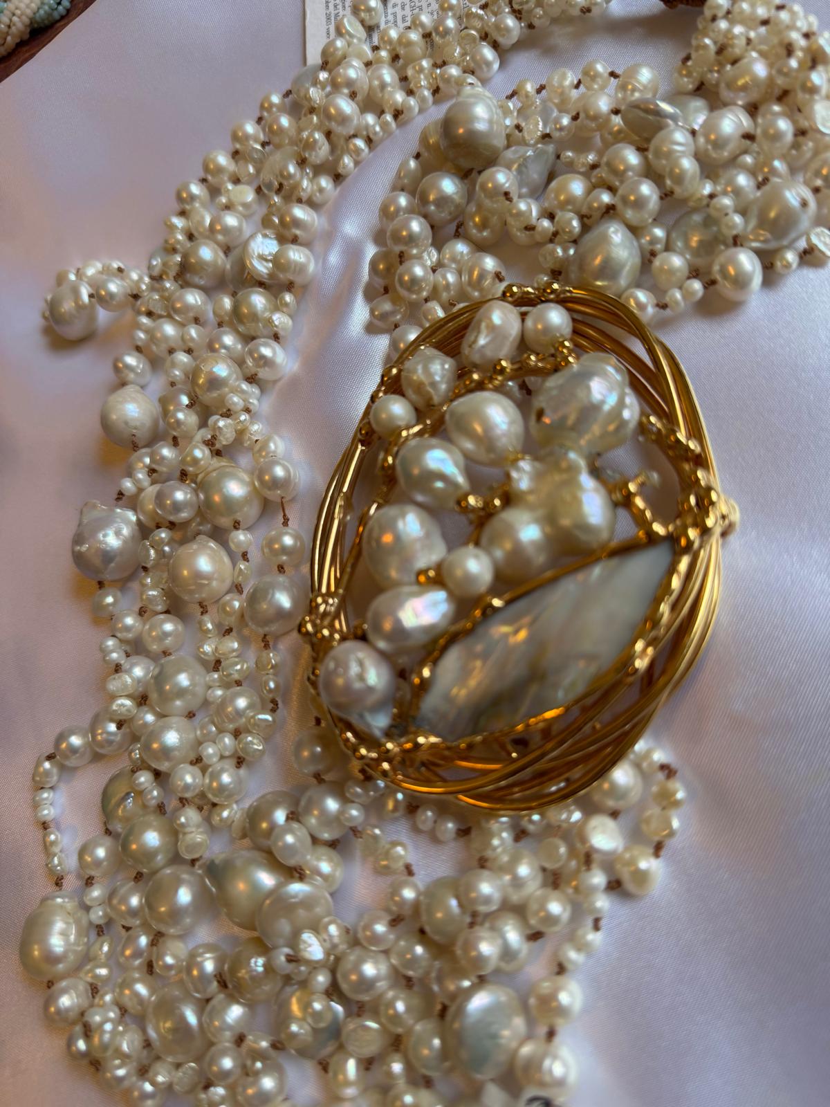 Multi-strand necklace with freshwater pearls and mother-of-pearl, in gold-plated metal.