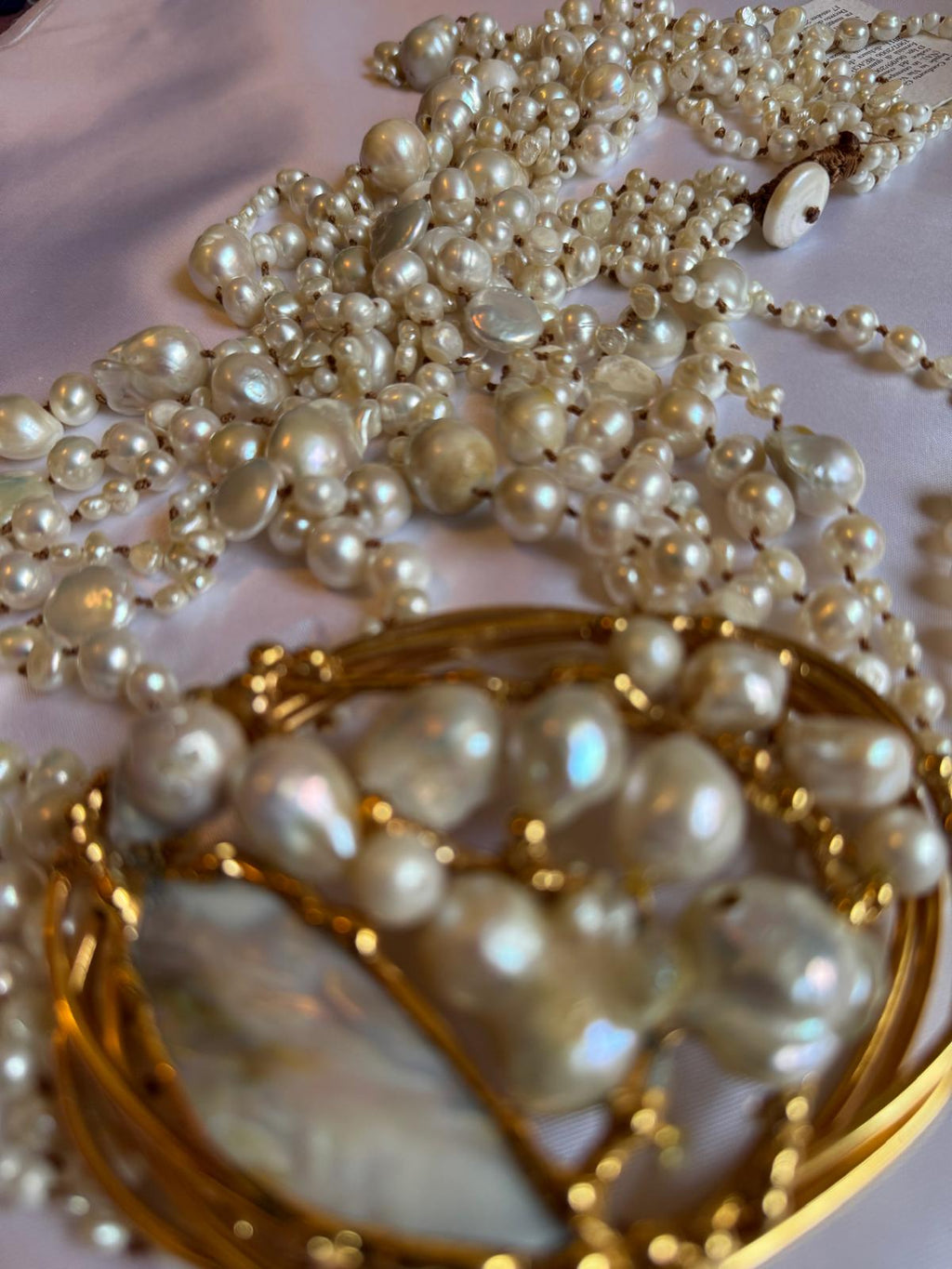 Multi-strand necklace with freshwater pearls and mother-of-pearl, in gold-plated metal.