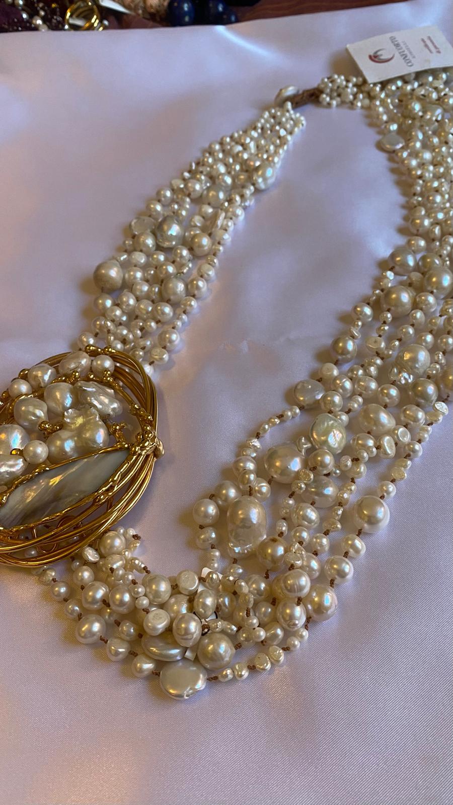 Multi-strand necklace with freshwater pearls and mother-of-pearl, in gold-plated metal.