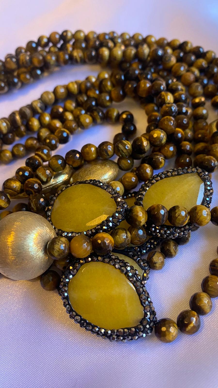 Collana multifilo realizzata in occhio di tigre, pepite d'oro e glitter con chiusura in madreperla.