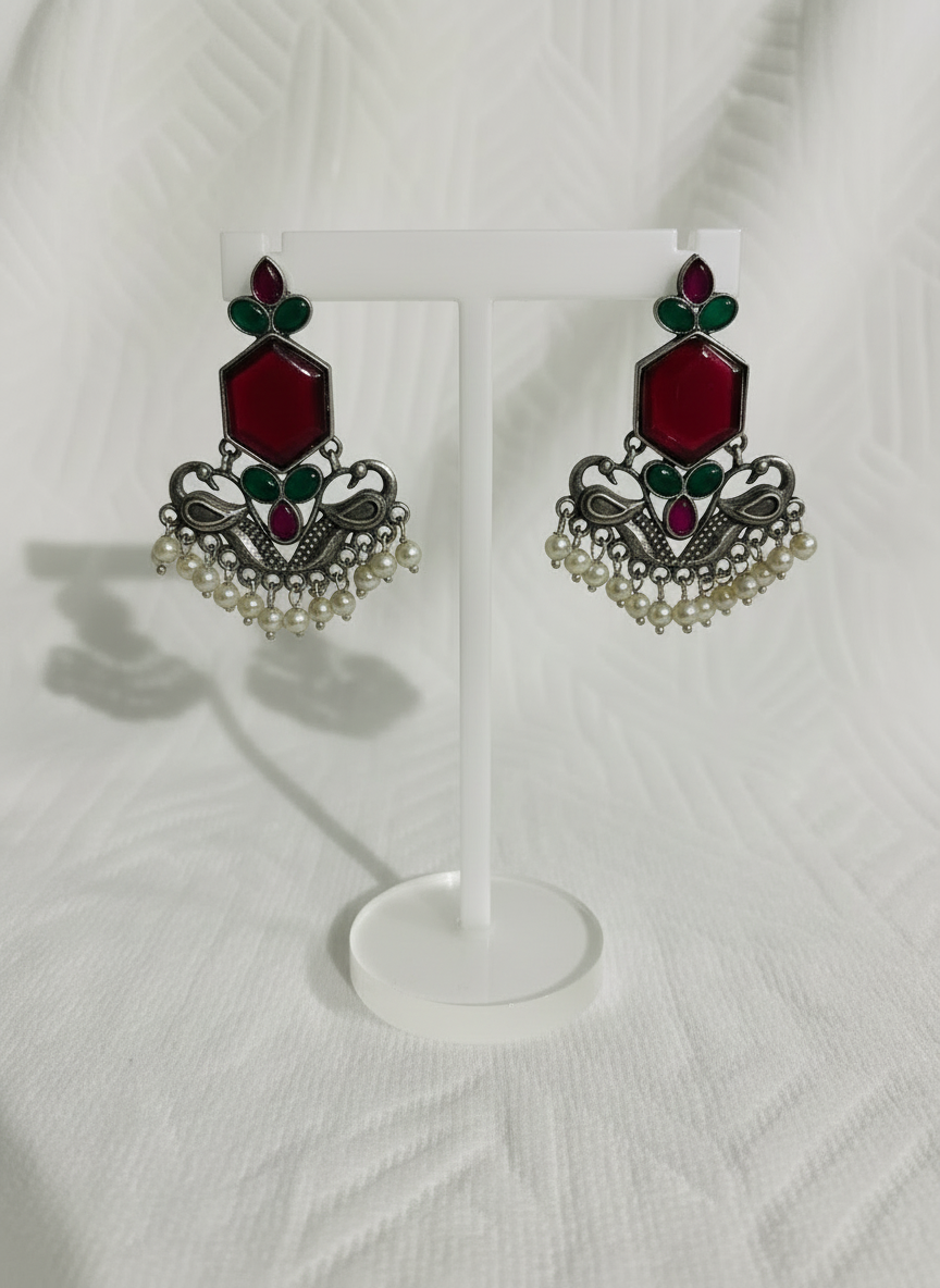 Boucles d'oreilles pendantes traditionnelles plaquées argent, ornées de pierres rouges et de perles.